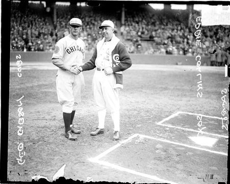 Cubs manager or player and White Sox player/manager Eddie Collins, shaking hands behind home plate on the field at Comiskey Park